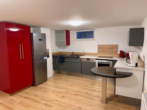 海尔布隆Especially souterrain apartment的厨房配有桌子和红色冰箱