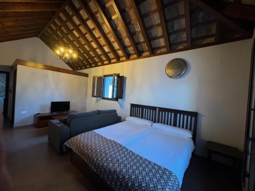 麦地那西多尼亚Posada Alegria的一间卧室配有一张床和一张沙发