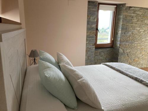 卢阿尔卡La Casina de Tano (Playa Tauran)的卧室配有带枕头的床铺和窗户。