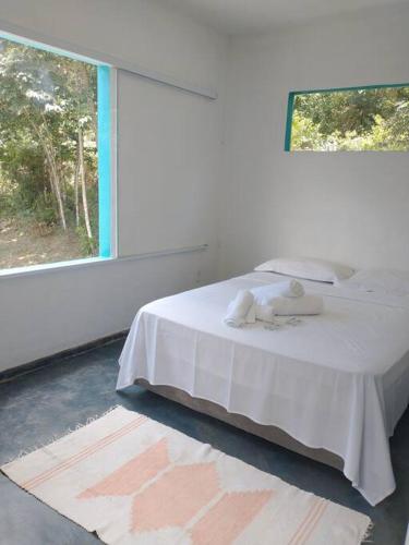 阿尤鲁奥卡Casa do Bosque的卧室配有白色的床和窗户