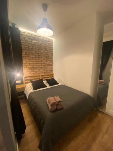 华沙Chillout Loft Apartment AL20的一间卧室设有一张大床和砖墙