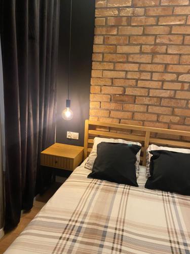华沙Chillout Loft Apartment AL20的一间卧室设有一张床和砖墙