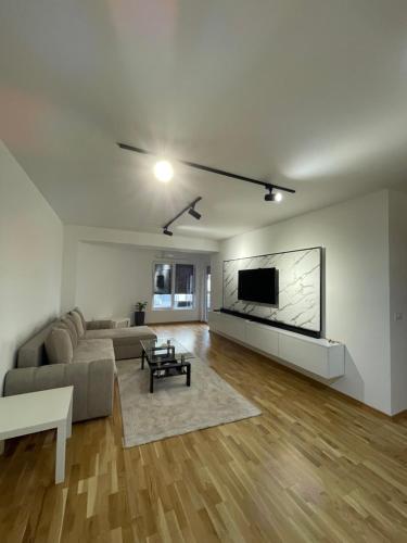 斯特鲁米察Diamond Apartment的客厅配有沙发和墙上的电视