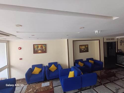 赫尔格达Palm Inn City Hotel的一间等待室,配有蓝色的椅子和黄色的枕头