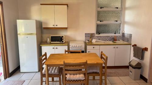 帕皮提DAMYR PLACE的厨房配有木桌和冰箱。
