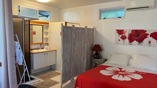 帕皮提DAMYR PLACE的卧室配有红色和白色的床和水槽。