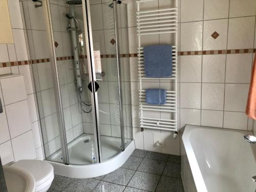 EsgrusFerienhaus Erdmann-Huus的带淋浴、浴缸和卫生间的浴室