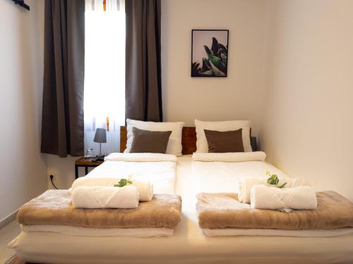 哥鲁拜克Golubina 3 - Soba sa Sopstvenim Kupatilom的一间卧室配有两张床、白色床单和毛绒枕头。
