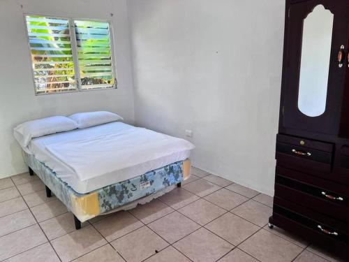 拉利伯塔德Casa en Condominios San Blas 5 minutos del Tunco的一间小卧室,配有一张床和一个梳妆台