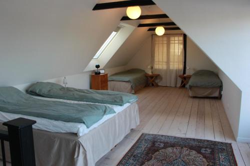 BjärredBjerred B&B的阁楼卧室配有两张床和地毯。