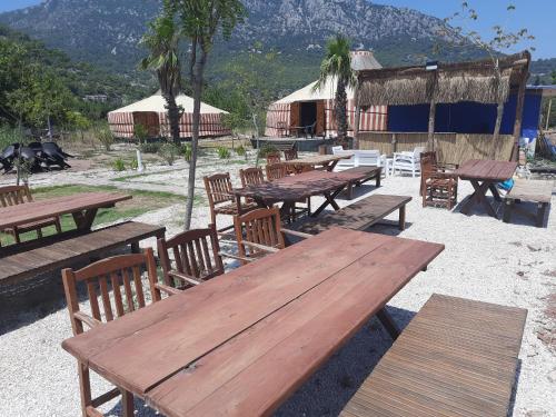 阿德拉桑Adrasan Yıldız Bungalow Tatil Köyü的一组野餐桌椅,背景是山间
