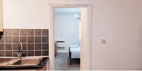 诺丁汉Cozy 1 Bedroom Flat Nr Nottingham的一个带水槽的厨房和一间带桌子的房间