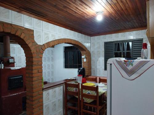 AlagoaHospedagem Manacás的厨房设有砖拱门和冰箱。