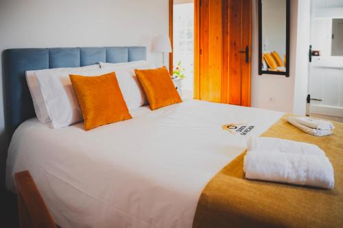 奥比多斯Casa de Campo da Quinta da Pegada的一张白色大床,上面有橙色枕头