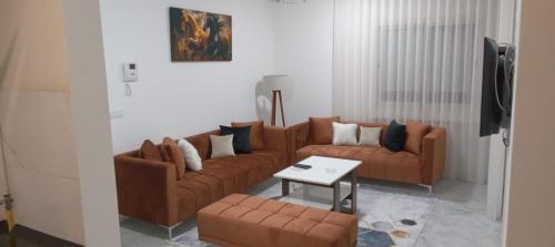 La SoukraBlack horse room soukra的客厅配有2张棕色沙发和1张桌子