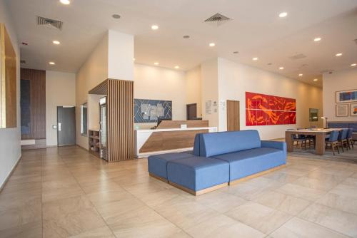 瓜达拉哈拉瓜达拉哈拉依特苏快捷假日酒店的一间带蓝色沙发的客厅和一间厨房