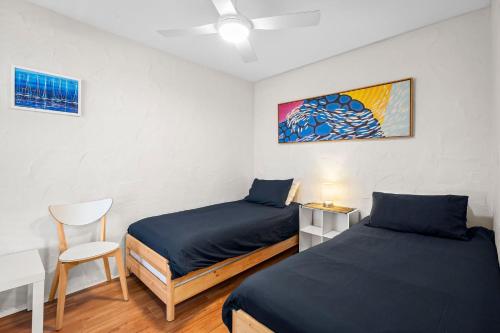 马库拉La Costa Del Sol的一间卧室配有两张床、一张桌子和一把椅子