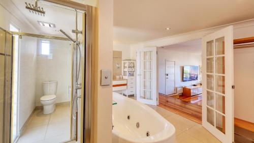 彭古因美德森精品酒店的带浴缸、卫生间和盥洗盆的浴室