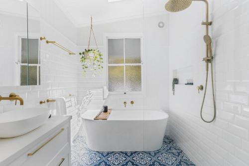 布里斯班Tranquil 2-Bed Family Home with Deck Among Trees的白色的浴室设有浴缸和水槽。