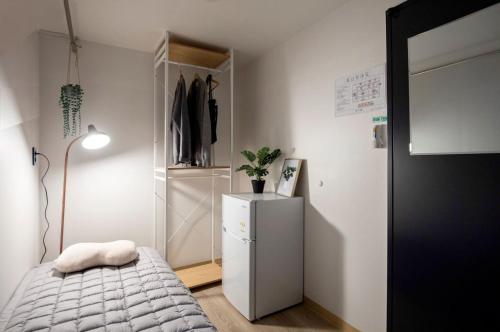 首尔9-RoD的一间带床和冰箱的小卧室