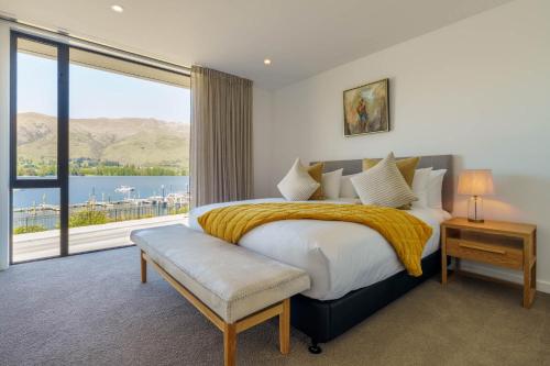 瓦纳卡Marina Terrace, Wanaka的一间卧室设有一张大床和一个大窗户