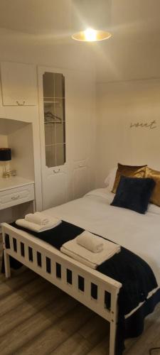 伦敦The Manor Guest House in Wembley的一间卧室配有两张床和一张书桌