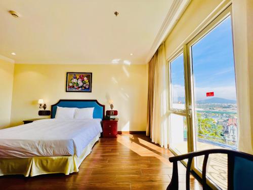 胡志良CALYSSA HOTELS & VILLAGE的酒店客房设有一张床和一个大窗户
