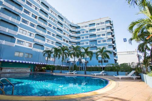 芭堤雅市中心萨瓦斯蒂暹罗酒店的一座大建筑前的游泳池