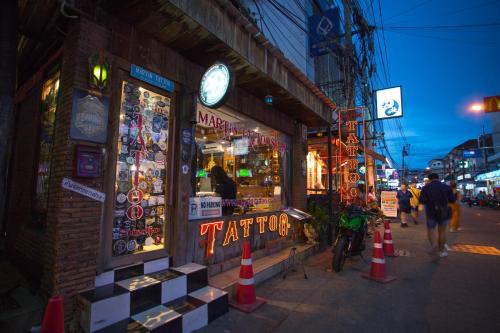 芭堤雅市中心萨瓦斯蒂暹罗酒店的建筑物边有时钟的商店