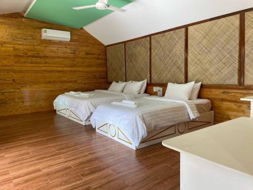 Phumĭ Srê ThmeiNov Koh Kong Resort的木墙客房的两张床