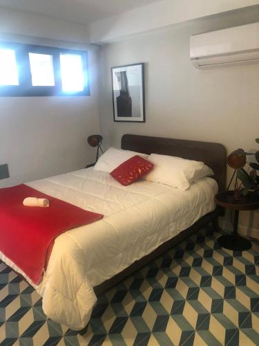 巴拿马城Apartamento Casco Antiguo的一间卧室配有一张床铺,床上铺有红色毯子