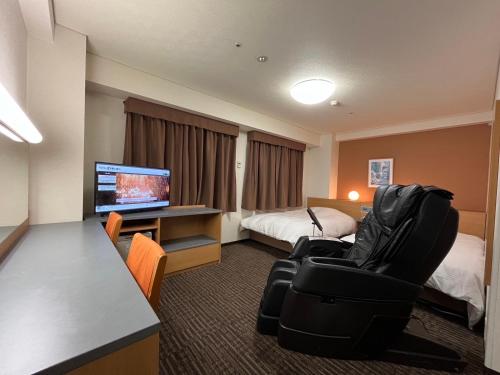 郡山Hotel Alpha-One Koriyama Higashiguchi的酒店客房,配有一张床、一张桌子和椅子