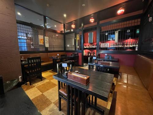 秋田Hotel Alpha-One Akita的一间带桌椅的餐厅和一间酒吧