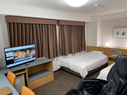 秋田Hotel Alpha-One Akita的配有一张床和一台平面电视的酒店客房
