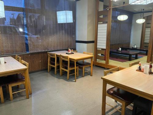 米泽市Hotel Alpha-One Yonezawa的用餐室配有木桌、椅子和乒乓球设施。