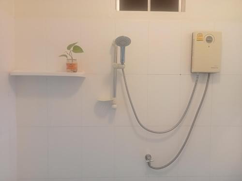 班佩幸福家园旅馆的白色浴室设有淋浴和软管