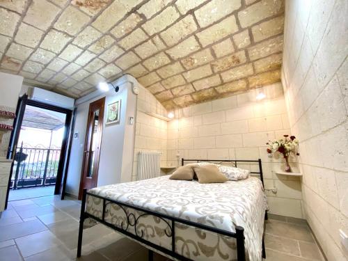莱切省卡斯特罗L' ATTICO CastroSalento的一间卧室设有一张床和砖墙