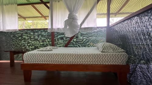希门尼斯港Ecoturístico La Tarde的一间卧室配有一张带天蓬和窗户的床