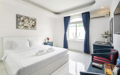 胡志明市La Casona Boutique Hotel的白色卧室配有床和椅子