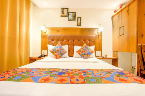 孟买FabHotel Anam International的一间卧室配有一张带彩色床罩的床