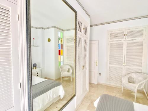 安特克拉Apartamento Andalucía Centro III的卧室内的镜子,配有一张床和椅子
