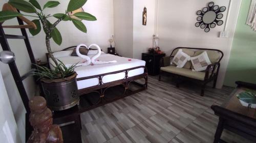 拉威海滩Baan sikhao Yanui的一间卧室配有一张带植物和椅子的床