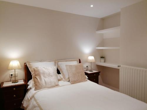 扎马亚Apartamento Costa con Parking Privado Incluido的一间卧室配有一张带两盏灯的大型白色床。