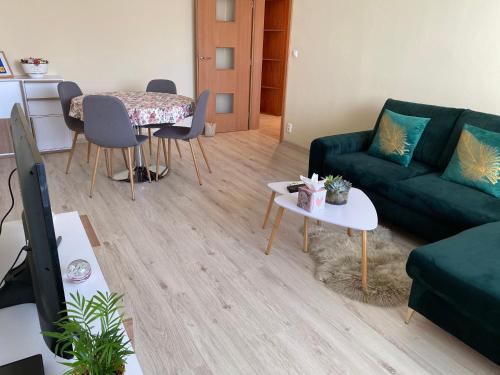 皮耶什佳尼City Apartment的客厅配有绿色沙发和桌子