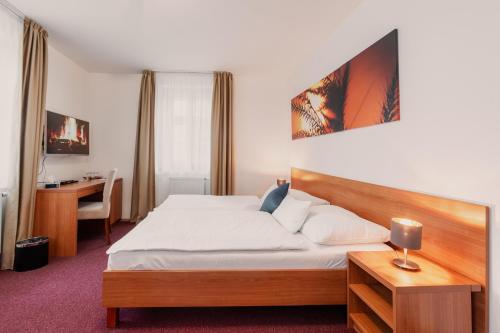 伊泽卡Hotel Jizerka 4的配有一张床和一张书桌的酒店客房