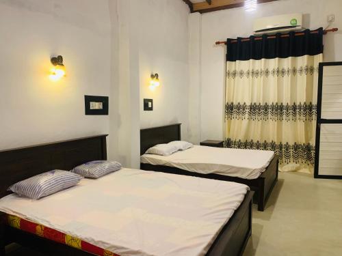 贝鲁沃勒Shehan Villa的客房设有两张床和窗户。