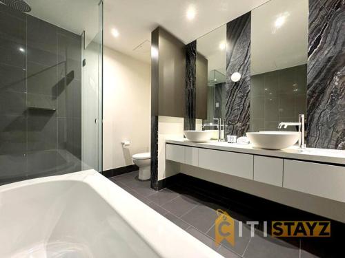 堪培拉Nice in New Acton - 2bd 2bth Apt的浴室配有两个盥洗盆和浴缸。