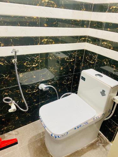 范兰德凡Nirupam Sadan HomeStay的浴室设有卫生间和黑色瓷砖墙