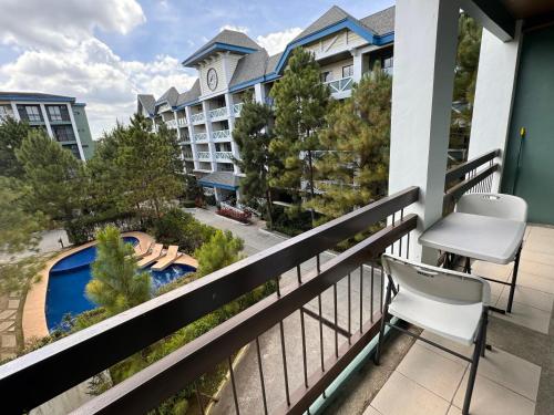 大雅台CozyVilla at Pine Suites Tagaytay 2BR or Studio with FREE PARKING的阳台配有椅子,享有酒店的景致。