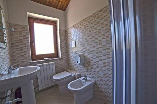 Masseria di RuscianoQUERCIA ANTICA的一间带水槽和卫生间的浴室以及窗户。